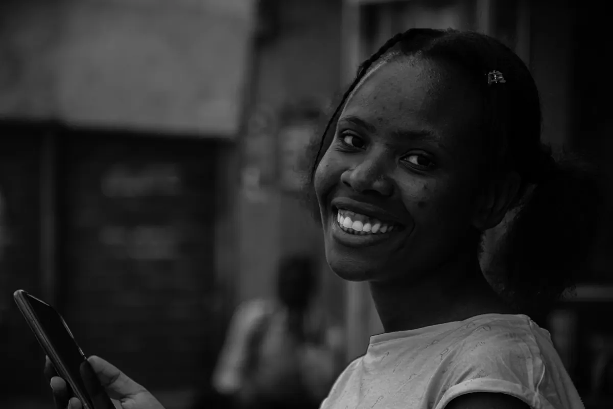 A woman smiling while looking at her mobile phone
