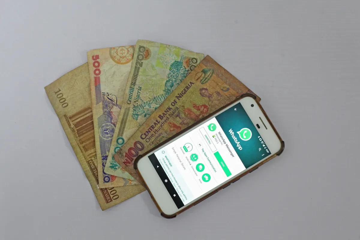 A mobile phone resting beside Kenyan banknotes